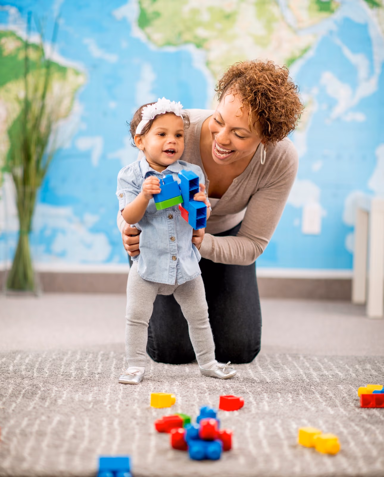 Toddler learning to walk with a teacher at New Life Early Learning Academy
